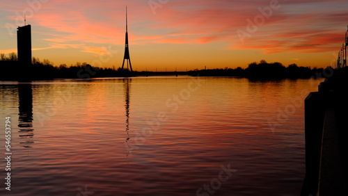 Reflection of the TV tower in the river against the background of dawn in Riga