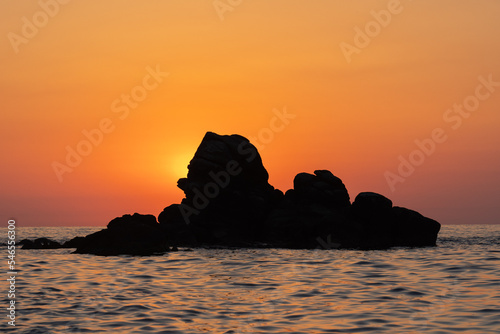 Beautiful view of orange sunset seascape with rocks in Italy. Tropical colorful sunrise landscape