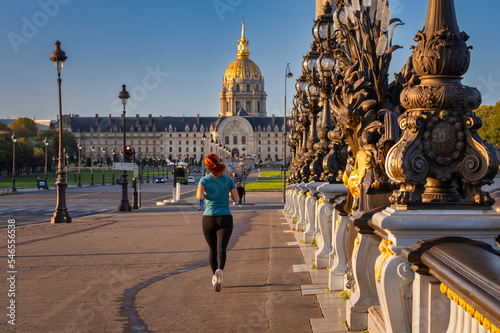 Fototapeta Naklejka Na Ścianę i Meble -  Woman jogging at the Pont Alexandre III bridge over the Seine river, Paris. France
