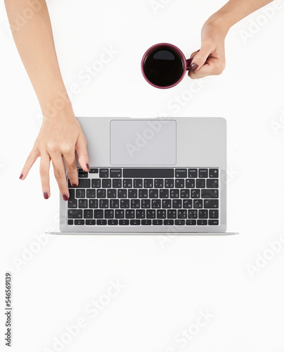 Woman using laptop at clean white office desk with coffee. Top View Stock Photo