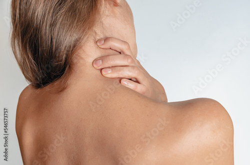 Massage for neck pain - woman with neck pain from behind  naked body.