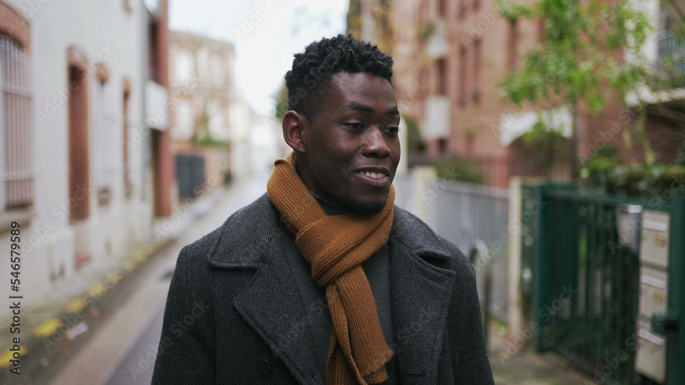 Confident elegant black African walks forward smiling during winter in Europe Confident elegant black African walks forward smiling during winter in Europe