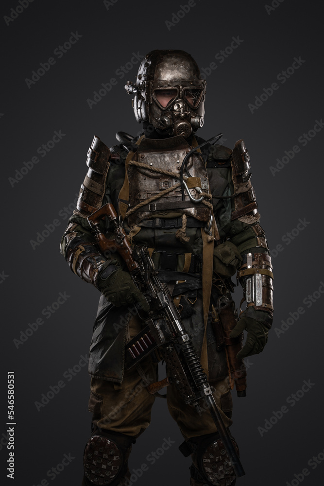 Shot of post apocalyptic soldier dressed in armour and gas mask holding shotgun.