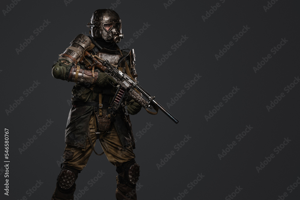 Studio shot of military man dressed in armored suit with shotgun against grey background. Studio shot of military man dressed in armored suit with shotgun against grey background.