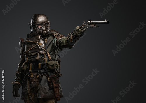 Shot of isolated on grey background soldier in setting of post apocalypse aiming pistol.