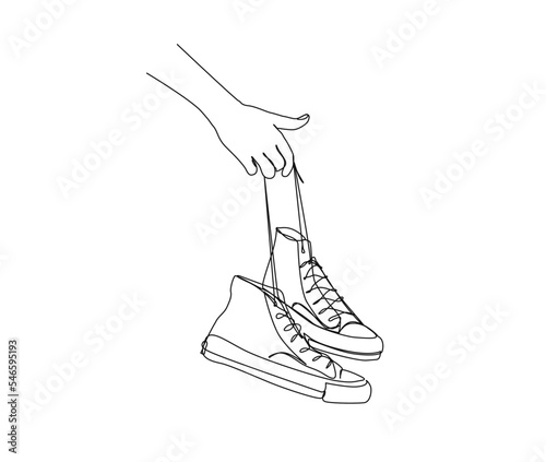 Continuous one line drawing of hand holding sneakers. Fashionable and casual sneakers line art drawing vector design. shoes lineart design.
