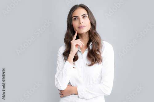 Portrait of young woman thinking, looking up empty space. Thoughtful serious model in studio looking away. Girl thought choose decide solve problems.