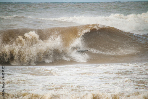 Fototapeta Naklejka Na Ścianę i Meble -  a surfer inside a breaking wave with muddy water
