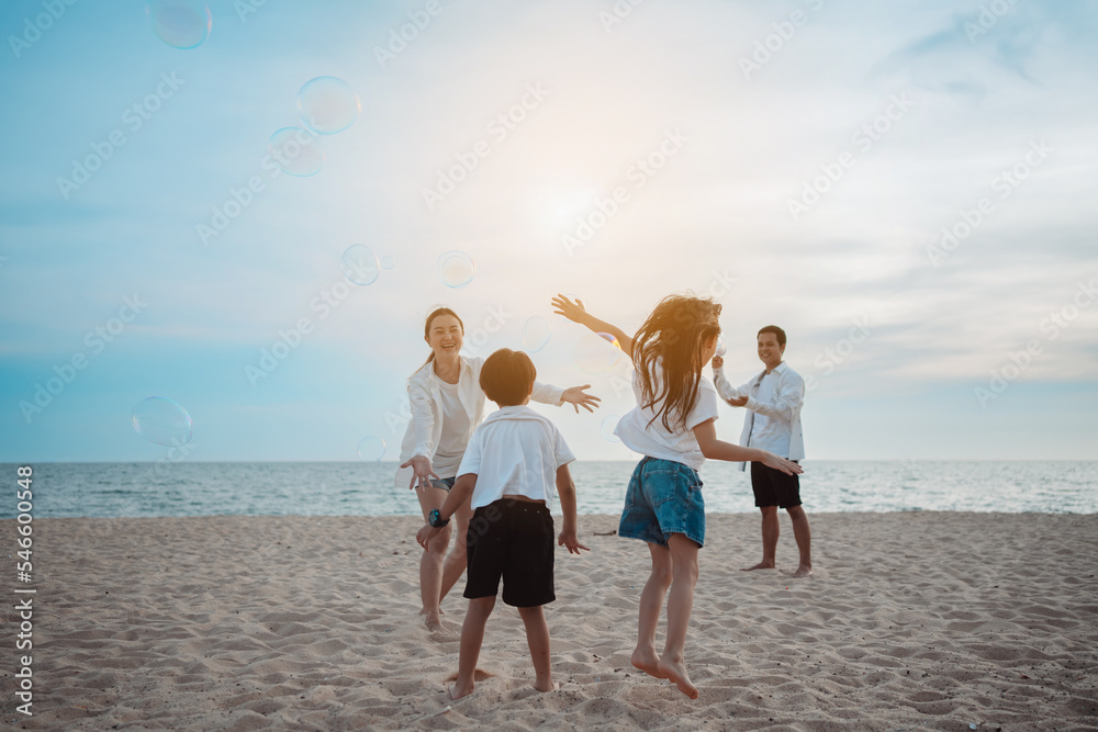 Happy asian family on the beach in holiday. of the family play blowing bubble.They are having fun playing enjoying on the beach. Summer Family and lifestyle. Happy asian family on the beach in holiday. of the family play blowing bubble.They are having fun playing enjoying on the beach. Summer Family and lifestyle.