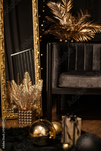 Merry Christmas and Happy Holidays!Beautiful black modern living room decorated for Christmas.Chrystmas Luxury black style living room interior with sofa decorated chic , golden style.Selective focus.