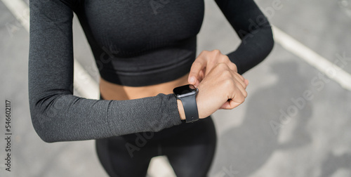 Uses a fitness watch bracelet. woman sports lifestyle fitness in the city cardio endurance training.