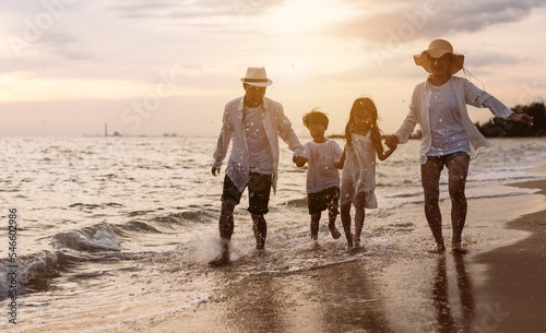 Happy asian family enjoy the sea beach at consisting father, mother,son and daughter having fun playing beach in summer vacation on the ocean beach. Happy family with vacations time lifestyle concept.