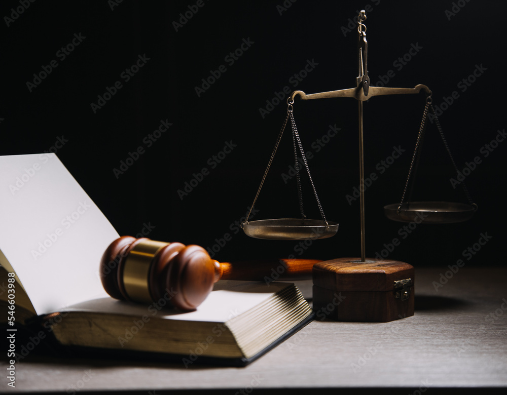 Justice and law concept.Male judge in a courtroom with the gavel, working with, computer and docking keyboard, eyeglasses, on table in morning light