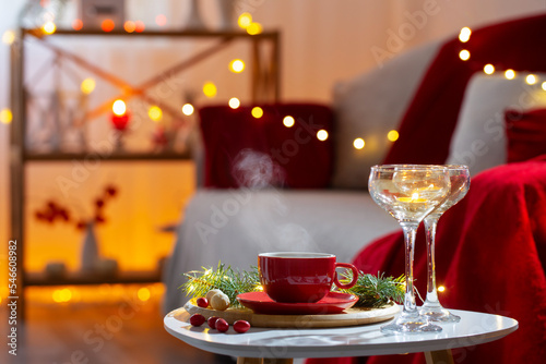 cup of hot drink with christmas decorations in white and red colors at home