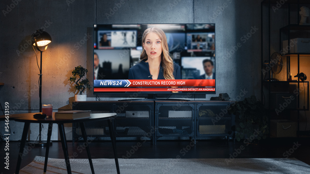 Stylish Loft Apartment Interior with TV Set with Evening News Show on Display. Monitor Standing on Television Stand. Empty Cozy Living Room of Spacious Flat with Female Presenter Reporting on Screen. - obrazy, fototapety, plakaty 