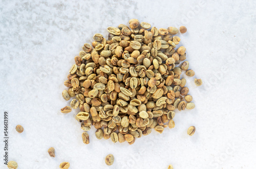 a pile of green bean coffee defect on marble background