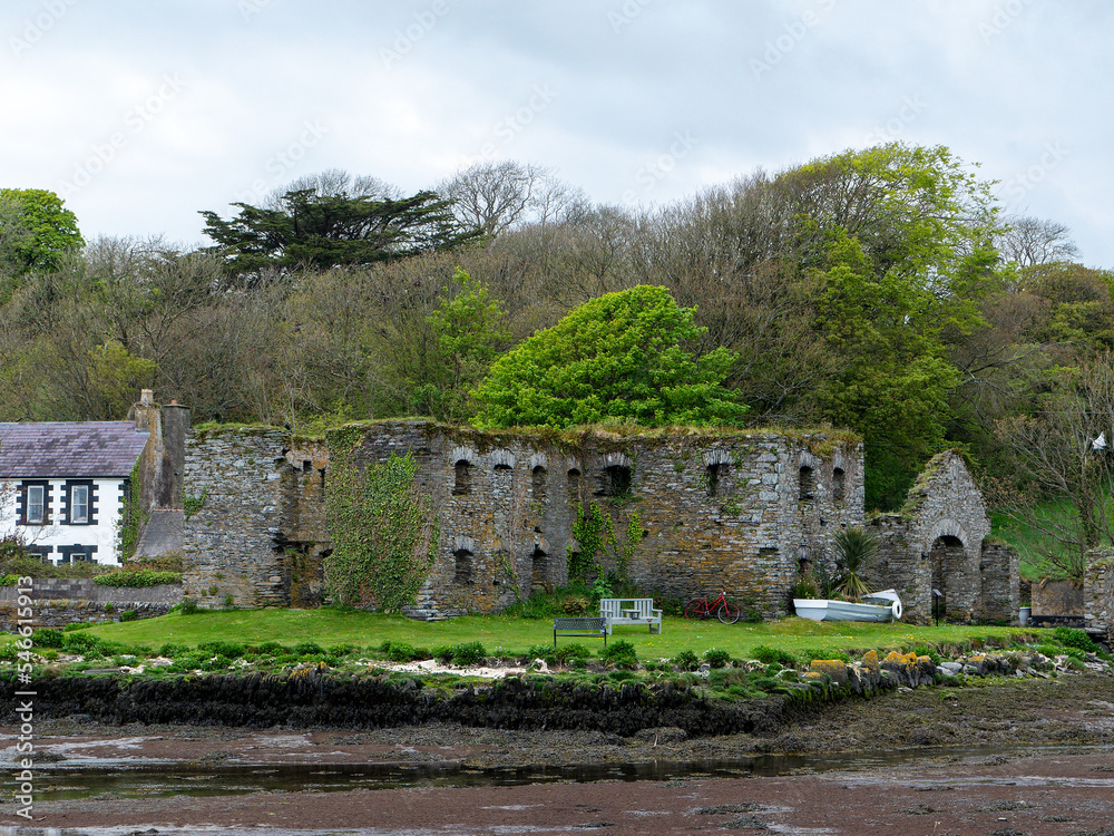 The Arundel grain store, shore of Clonakilty Bay in the spring. An old stone building in Ireland, Europe. Historical architectural monument, landscape. Tourist attractions in Ireland