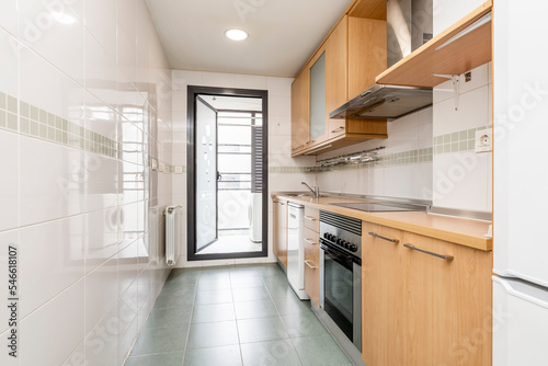 Kitchen with light cherry cabinets, built-in appliances and access to a grocery terrace