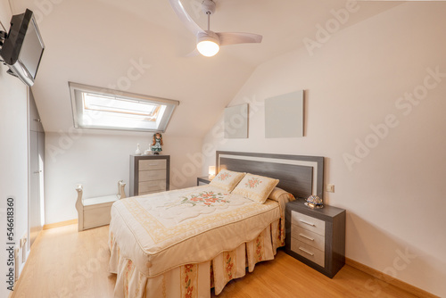 Bedroom with a double bed with a wooden headboard to match the bedside tables and the chest of drawers