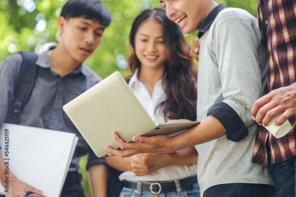 Group of Diversity Student talking and laughing together at asian college, working on laptop and smart phone. Happy multi ethnic friend successfully completes the thesis report and passed final exam Group of Diversity Student talking and laughing together at asian college, working on laptop and smart phone. Happy multi ethnic friend successfully completes the thesis report and passed final exam