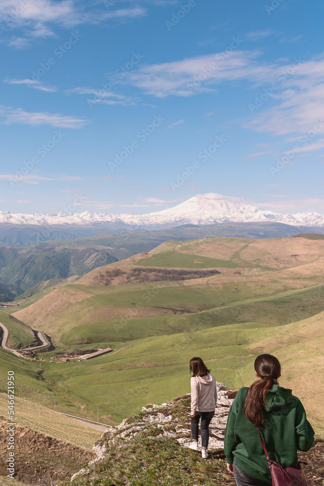 Caucasus, Russia - May 27, 1922 - an adult woman and her daughter admire the snow-covered peak of Elbrus