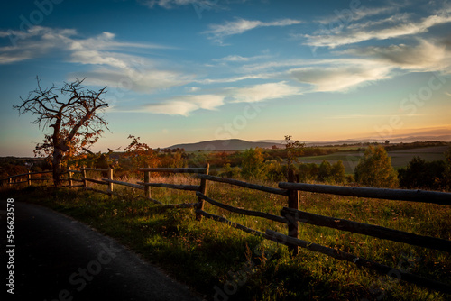 Autumnal sunset landscape with Great Owl (Wielka Sowa) Mountain, Poland. Old apple tree and a wooden fence in foreground. 