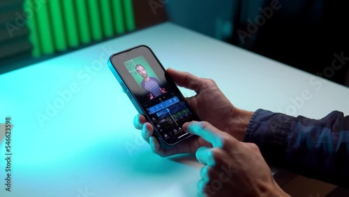 the video editor program on the phone. A young man is editing a video on his phone