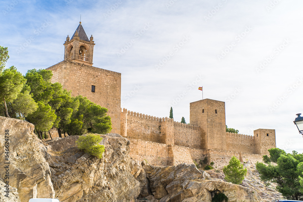 Alcazaba de Antequera. old medieval castle. stone walls, towers, stone buildings. horizontally and vertically, sunlight, blue sky and clouds