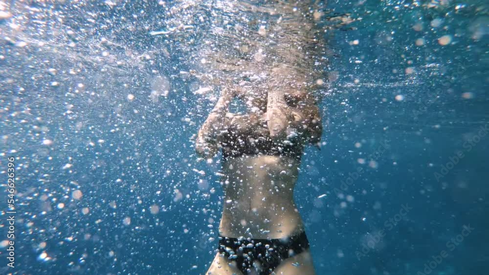 Girl with tattoo Swimming underwater. Young woman diving next to the the coral barrier. Swimming and snorkelling among fish and corals. Deep blue water for Free dive in the blue ocean reef.