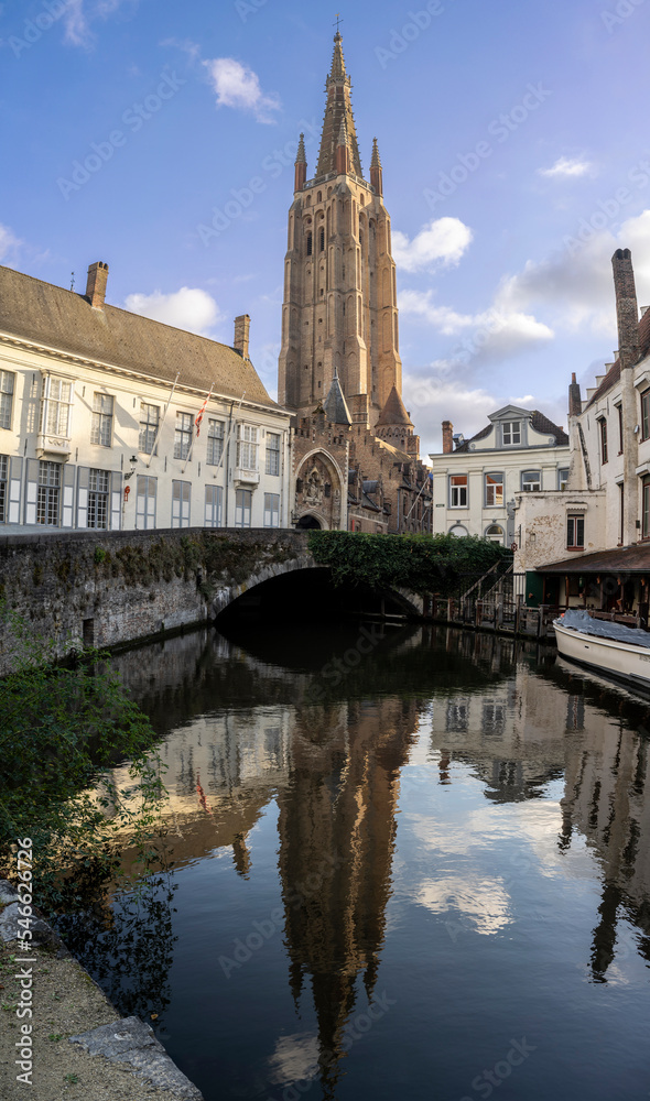 Bruges, Belgium: view of the canal and the Church of our Lady on background 
