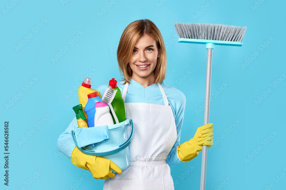 woman in gloves holding bucket of detergents and broom woman in gloves holding bucket of detergents and broom