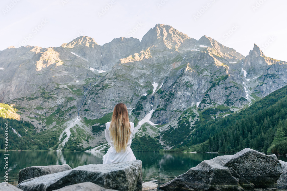 Φωτογραφία view of rocky mountains and lake. back view of a girl in a white