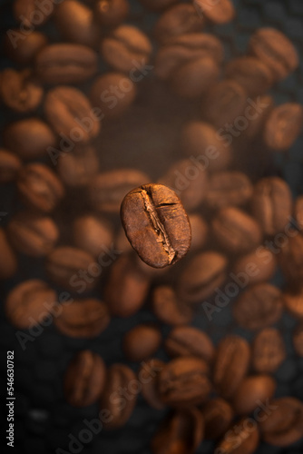 Roasting coffee with smoke. Macro photography of coffee beans on the background of coffee with steam. Flying coffee bean.