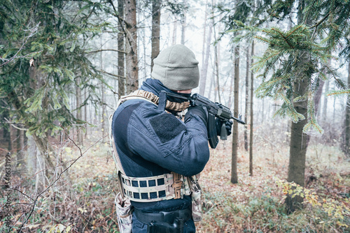 An armed soldier patrols the forest
