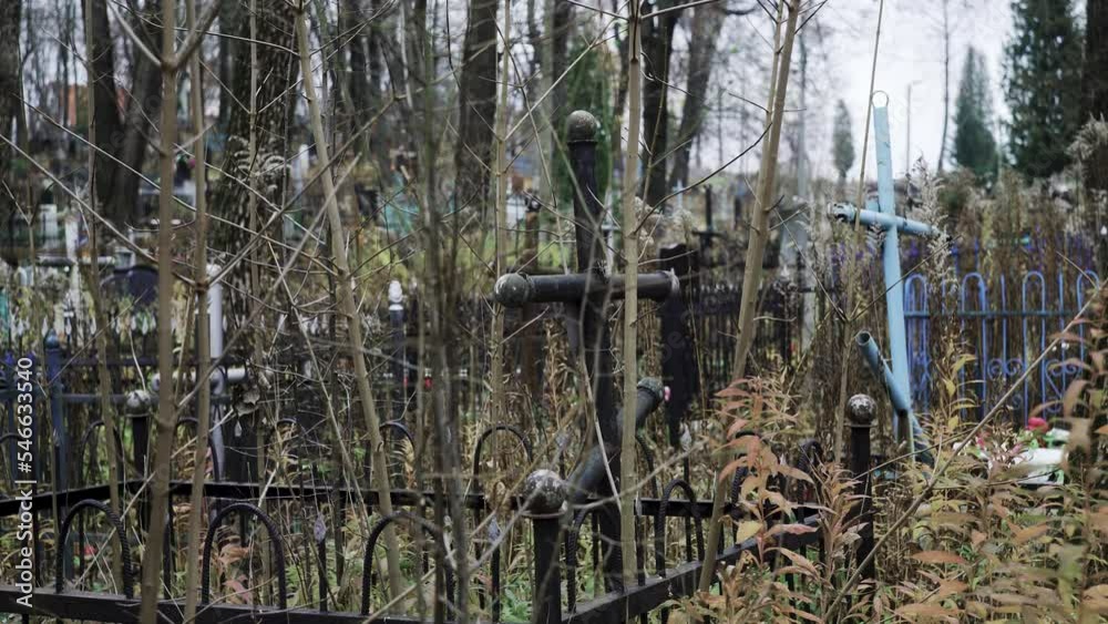 Religious cross in cemetery. Spooky cemetery landscape with old tombstones Religious cross in cemetery. Spooky cemetery landscape with old tombstones