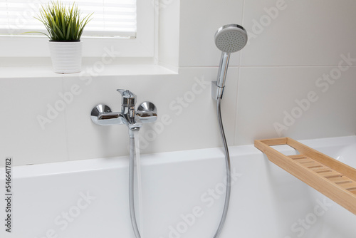Close-up of faucet and hand shower in bathroom