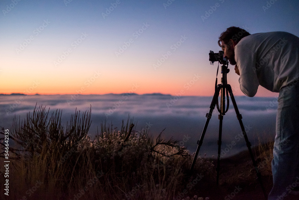 Man photographing with camera against sky during sunset Man photographing with camera against sky during sunset