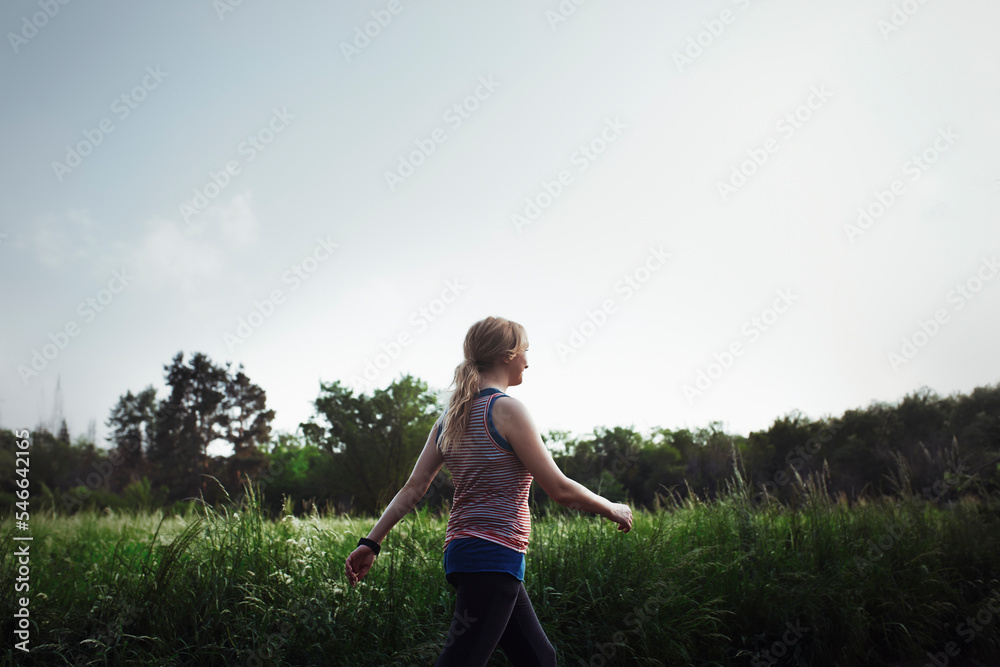 Side view of woman jogging against sky at park Side view of woman jogging against sky at park