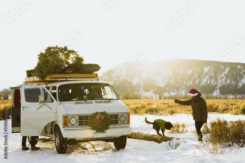 Woman plays with dog taking a break from driving in white van photo