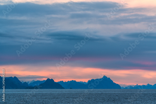 Cloudy sky on mountains and Norwegian sea at sunrise