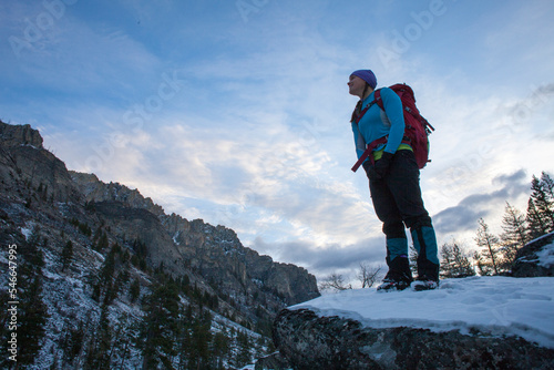 A woman hikes at dawn to an ice climb in Blodgett Canyon, Bitterroot Mountains, Montana. photo