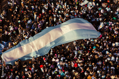 Multitud festejando con la bandera Argentina.