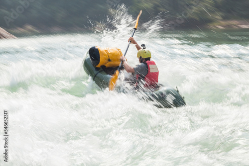 Man paddling his raft down rapid river on the Nam Ou River, Laos photo