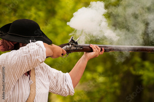 Historical reenactor firing a musket in Jamestown, Virginia. photo