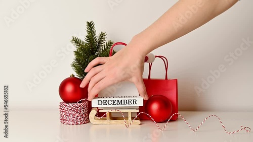 Unrecognizable female hand putting december vlock on sleigh. Christmas or new year concept photo