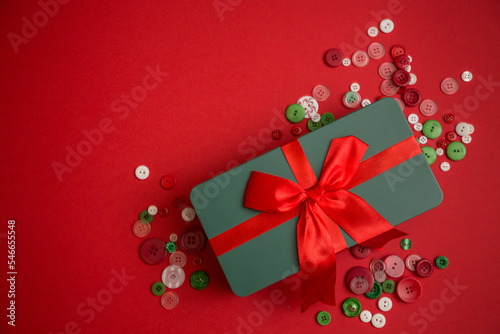Grünes Geschenk mit roter Schleife auf rotem Hinergrund