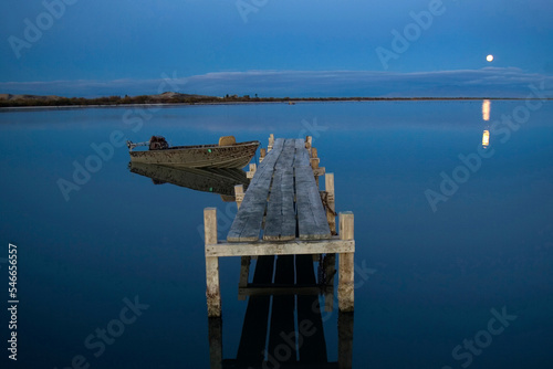 Boat dock at dawn with the moonset near Red Hill Marina in Salton Sea State Park, California, USA.