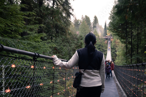 Canada Autumn travel destination in British Columbia. Tourists walking in famous attraction Capilano Suspension Bridge Park in North Vancouver, Canadian vacation for tourism.