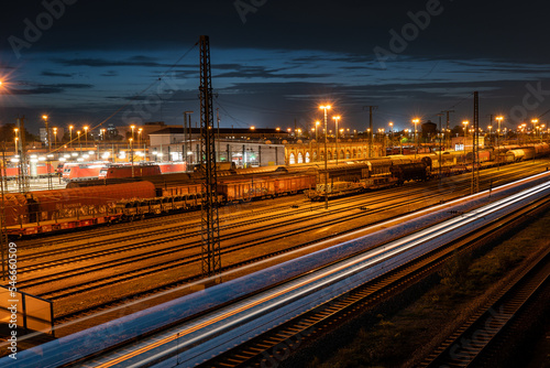 Cargo train station in Mannheim at night with moving train