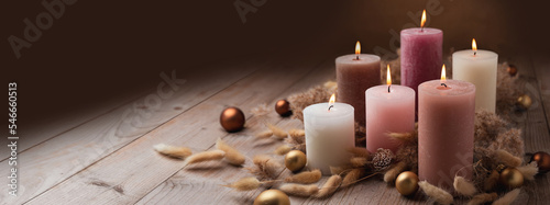 Natural Christmas Advent candles decoration in warm trend colors with dried lagurus and pampas grass on wood background. Winter cozy style, Hygge concept.